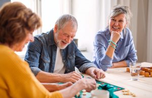 Group of senior people playing board games in community center club