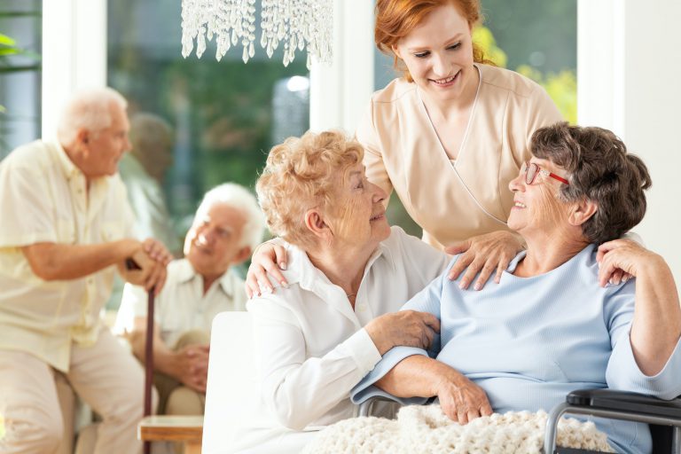 Happy friendship in old age. Tender caregiver standing behind se