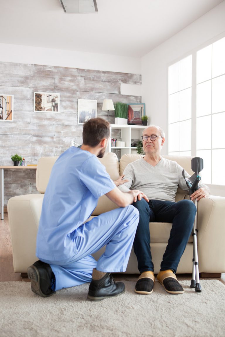 Young doctor holding old man arm in nursing home