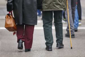 Elderly people croosing a street. Pensioner, adult care. Horizontal