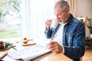 Senior man eating breakfast at home.
