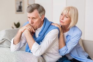 Senior woman consoling husband after arguing at home